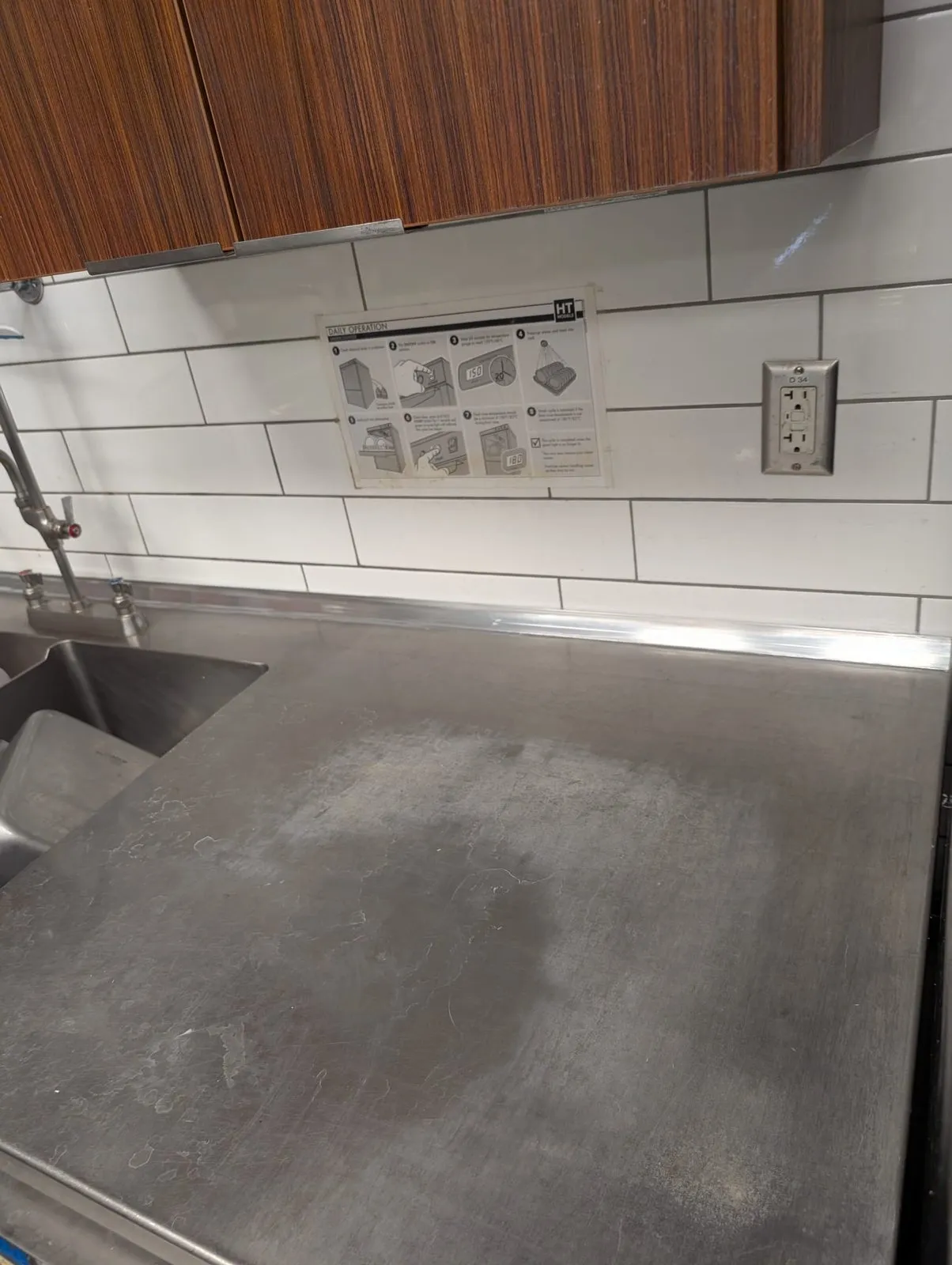 Stainless prep surface polished to uniform finish with refreshed white tile backsplash