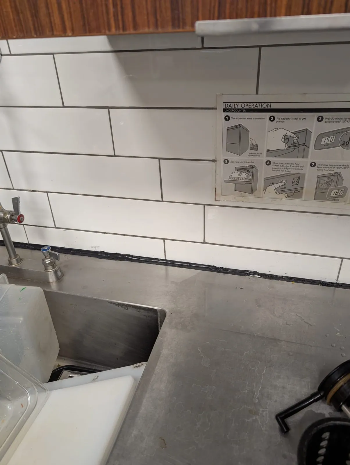 Scratched stainless steel prep counter in a Vancouver commercial kitchen before polish
