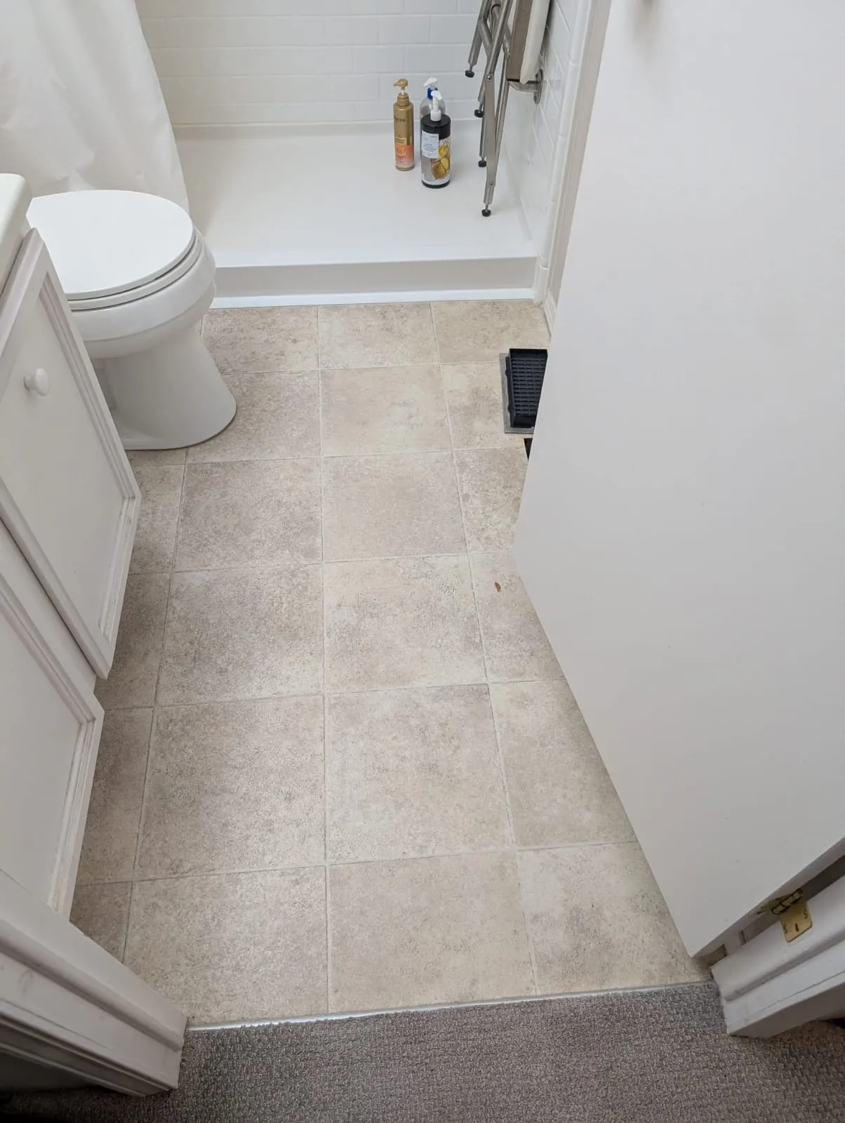 Old textured bathroom floor tile in a Metro Vancouver home before replacement