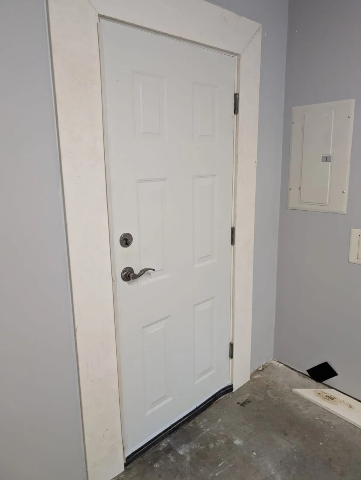 New white six-panel door hung and trimmed on the garage side of a Metro Vancouver home